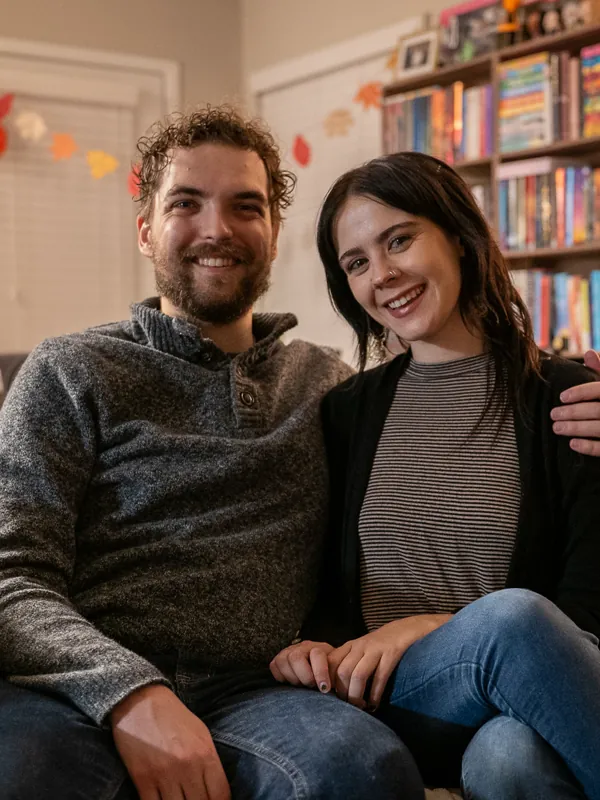 Jacob and Vicki sitting close together in a bookshelf-lined room