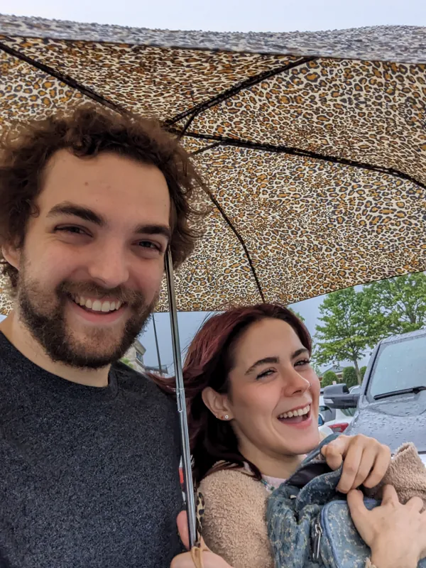 Jacob and Vicki laughing under a patterned umbrella